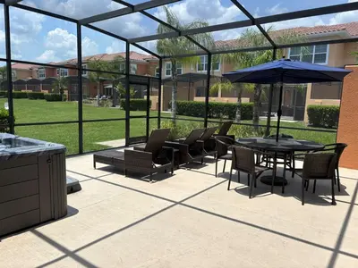 a patio with a table and chairs and an umbrella at Waterfront ParadiseClose 2 DisneyGated Community in Orlando