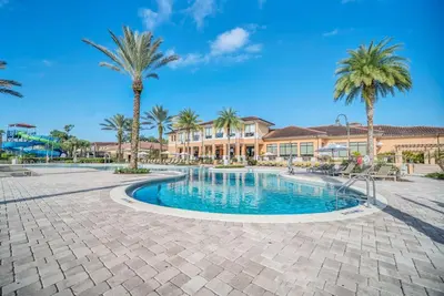 a swimming pool with palm trees and a building at Waterfront ParadiseClose 2 DisneyGated Community in Orlando