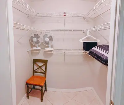 a room with a closet with a chair and a fan at Villa Velera in Kissimmee