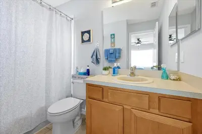 a bathroom with a toilet and a sink and a mirror at Emerald Island Resort 6 Bed Pool & Spa villa in Kissimmee