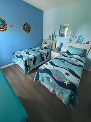 two beds in a room with blue walls at Emerald Island Resort 6 Bed Pool & Spa villa in Kissimmee