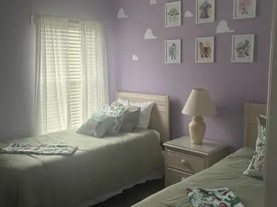 a bedroom with two beds and a lamp and a window at Emerald Island Resort 6 Bed Pool & Spa villa in Kissimmee