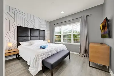 a bedroom with a large bed and a window at Beautiful 3 Bedroom Villa with Private Hot Tub, 10 mins to Disney! in Kissimmee