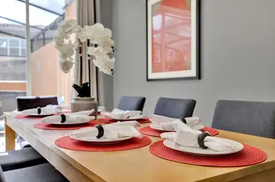 a table with red napkins and white plates on it at Beautiful 3 Bedroom Villa with Private Hot Tub, 10 mins to Disney! in Kissimmee