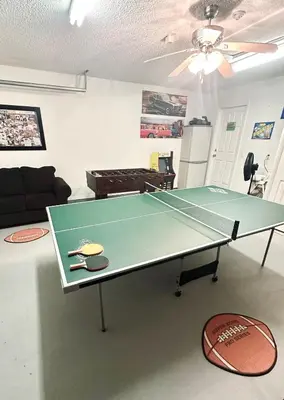 a ping pong table in the middle of a living room at Family Home, Near Disney-Private pool, Spacious 3BR Retreat in Orlando