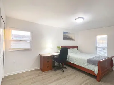 a bedroom with a bed and a desk with a chair at Happy Home in Orlando
