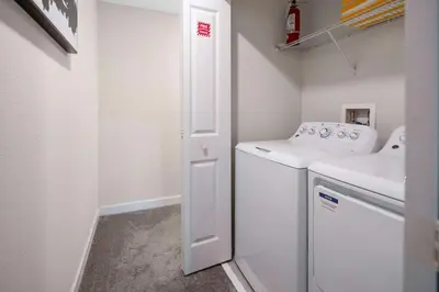 a small laundry room with a washer and dryer at Family Stylish 4BR Pool Townhome Storey Lake in Kissimmee