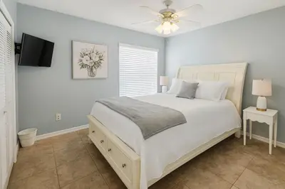 a bedroom with a white bed and a ceiling fan at Villa Central com Piscina perto da Disney in Kissimmee