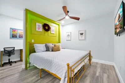 a bedroom with a bed with a green headboard at Serenity Spring Lake King Suite in Orlando