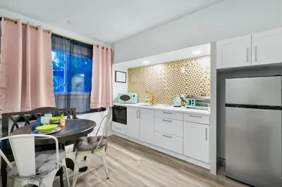 a kitchen with white cabinets and a table with chairs at Serenity Spring Lake King Suite in Orlando