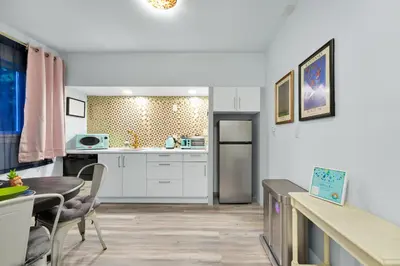 a kitchen with white cabinets and a table and a dining room at Serenity Spring Lake King Suite in Orlando