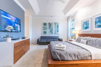 a bedroom with a large bed and a couch at Elsa's Enchanting Escape just 15 minutes to Disney in Kissimmee