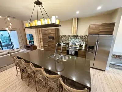 a kitchen with a black counter top and a refrigerator at Luxurious 4bed Villa Just 10 Minutes from Disney! Private BBQ in Orlando