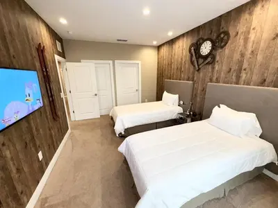 a bedroom with two beds and a flat screen tv at Luxurious 4bed Villa Just 10 Minutes from Disney! Private BBQ in Orlando