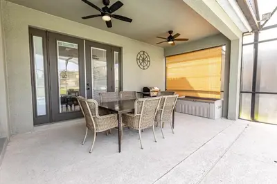 a dining room with a table and chairs on a patio at 6BR Fun Villa – Game Room, Pool, Near Parks in Kissimmee