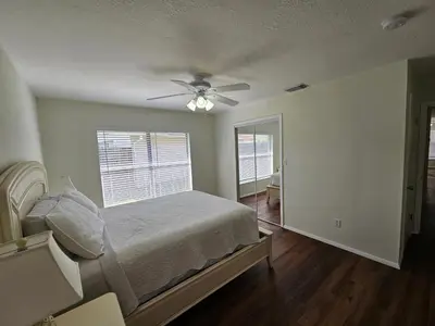 a bedroom with a bed and a ceiling fan at Magical Getaway- Cozy Home Minutes from Disney, Restaurants & Outlets! in Kissimmee