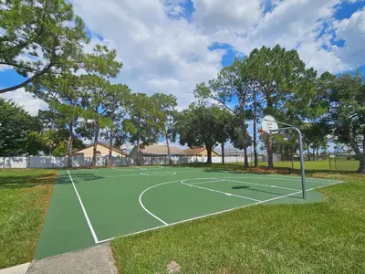 a basketball court with a hoop in a park at Magical Getaway- Cozy Home Minutes from Disney, Restaurants & Outlets! in Kissimmee