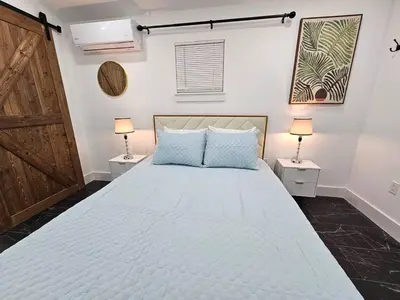 a bedroom with a large bed with two lamps at Comfy Tiny Home WP Large Private Deck Queen bed in Orlando