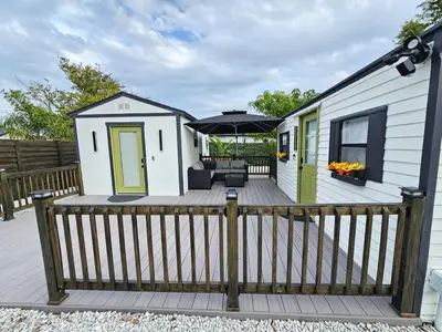 a tiny house with a deck with an umbrella at Comfy Tiny Home WP Large Private Deck Queen bed in Orlando