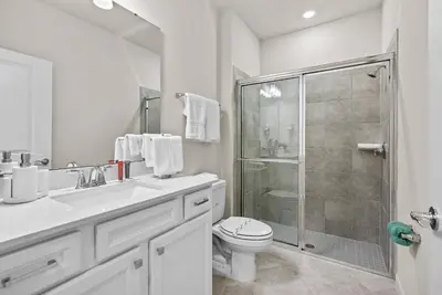 a white bathroom with a toilet and a shower at Brand New 05 Bedrooms At Windsor Cay in Orlando