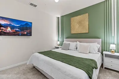 a bedroom with a large bed with a green wall at Brand New 05 Bedrooms At Windsor Cay in Orlando