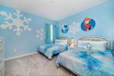 a blue bedroom with two beds and snowflakes on the wall at The Venue Mansion in Kissimmee