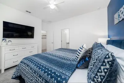 a bedroom with a bed and a tv on a wall at The Venue Mansion in Kissimmee