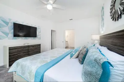 a bedroom with a bed with a tv on the wall at The Venue Mansion in Kissimmee