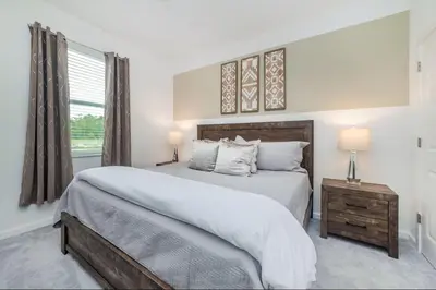 a bedroom with a large bed and a window at The Venue Mansion in Kissimmee