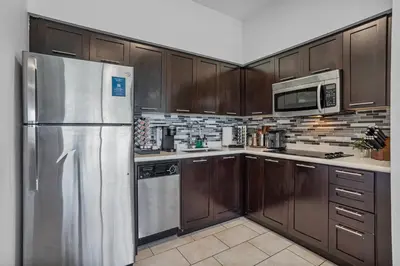 a kitchen with wooden cabinets and a stainless steel refrigerator at Spacious Pet Friendly in Orlando