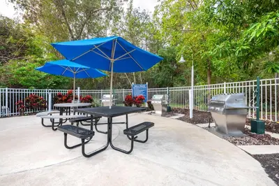 a table with two chairs and a blue umbrella at Hilton Vacation Club Cypress Pointe Orlando in Orlando