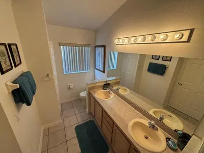 a bathroom with two sinks and a large mirror at Relaxing 3BR/2BA Home - Just 15 Minutes from Disney! in Kissimmee
