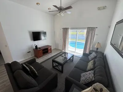 a living room with a couch and a tv at Relaxing 3BR/2BA Home - Just 15 Minutes from Disney! in Kissimmee