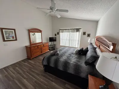 a bedroom with a large bed and a ceiling fan at Relaxing 3BR/2BA Home - Just 15 Minutes from Disney! in Kissimmee