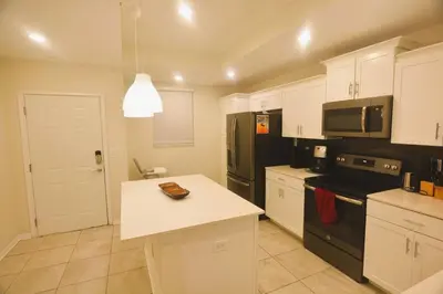 a kitchen with white cabinets and a black refrigerator at Storey Lake Resort Condo next to Disney in Kissimmee