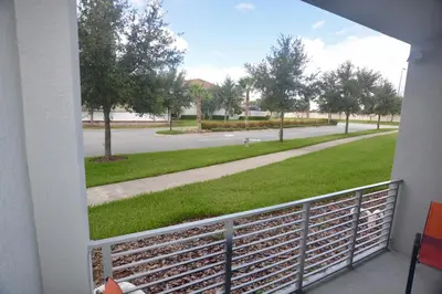 a balcony with a view of a street with trees at Storey Lake Resort Condo next to Disney in Kissimmee
