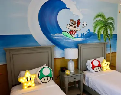 a bedroom with two beds and a painting of a surfer at Best Margaritaville Villa Near Disney World in Orlando