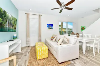 a living room with a white couch and a table at Best Margaritaville Villa Near Disney World in Orlando