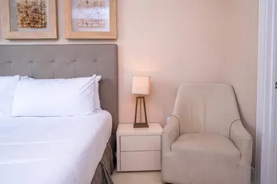 a bedroom with a bed and a chair and a lamp at Modern Magic Village Home for 12 with Grill 3131 in Orlando