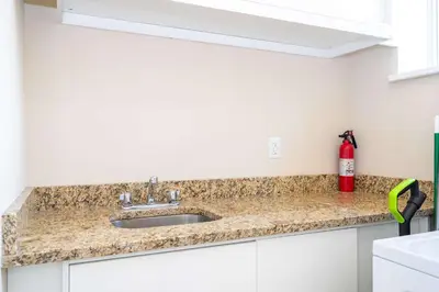 a kitchen counter with a sink and a red fire extinguisher at Modern Magic Village Home for 12 with Grill 3131 in Orlando