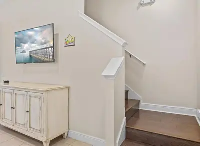 a living room with a staircase with a tv on the wall at Bikinis and Martinis - For 6 in Orlando