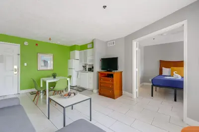 a living room with green walls and a bedroom at 2 Mi to Disney and Old Town Resort Condo with Perks in Orlando