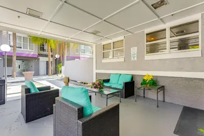 a patio with wicker chairs and tables with blue cushions at 2 Mi to Disney and Old Town Resort Condo with Perks in Orlando