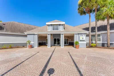 a house with palm trees and a brick driveway at 2 Mi to Disney Resort Condo with Pool Access in Orlando