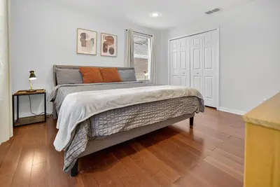 a bedroom with a large bed with orange pillows at 290 LF - BellaVida Cozy 6BR Pool Home in Kissimmee