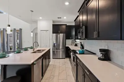 a kitchen with black cabinets and stainless steel appliances at 4238 Paragraph in Kissimmee