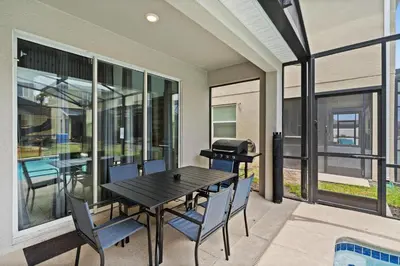 a patio with a table and chairs and a grill at 4238 Paragraph in Kissimmee