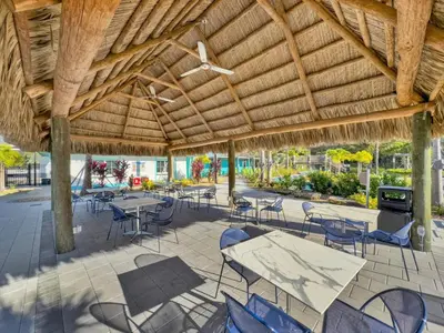 a patio with tables and chairs under a wooden roof at 4238 Paragraph in Kissimmee