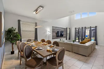 a dining room with a table and chairs and a couch at 4238 Paragraph in Kissimmee