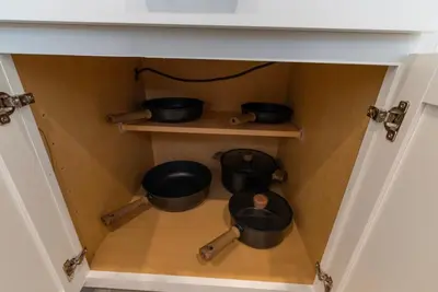 a cupboard with pots and pans in it at Remote workers apartment or Long Stay Home